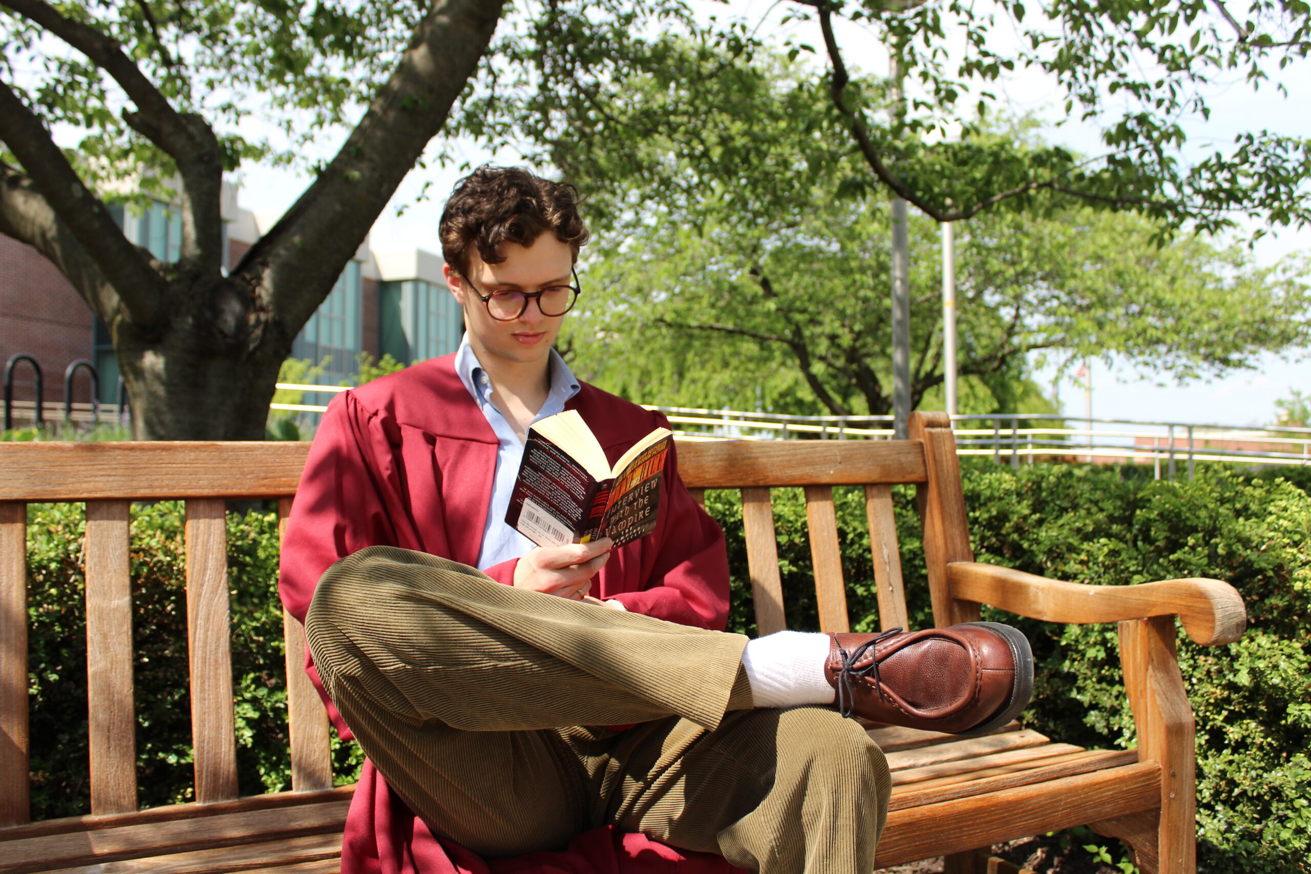 Grad student sitting on bench reading